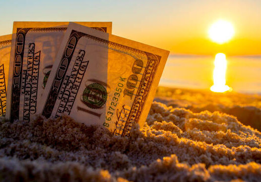 24-44 Three dollar bills are buried in sand on sandy beach near sea at sunset dawn in summer close-up. Money. Dollars covered sand. Money grows in ground. Finance and investment concept.
